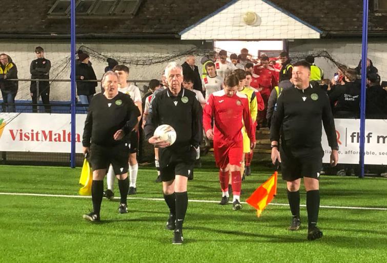 Match officials lead out the teams